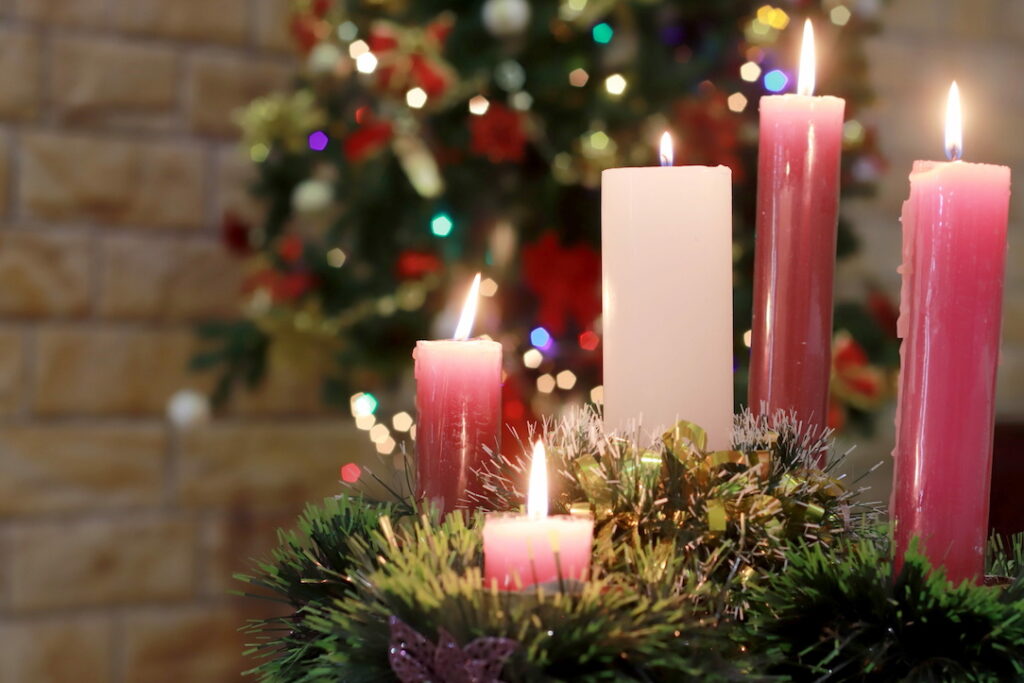 All five advent candles lit with tree and wreath sparkling