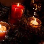 Three votive holiday candles twinkling with wreath