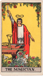 The Magician Waite-Smith Tarot man in robe pointing down holding up wand with table in front