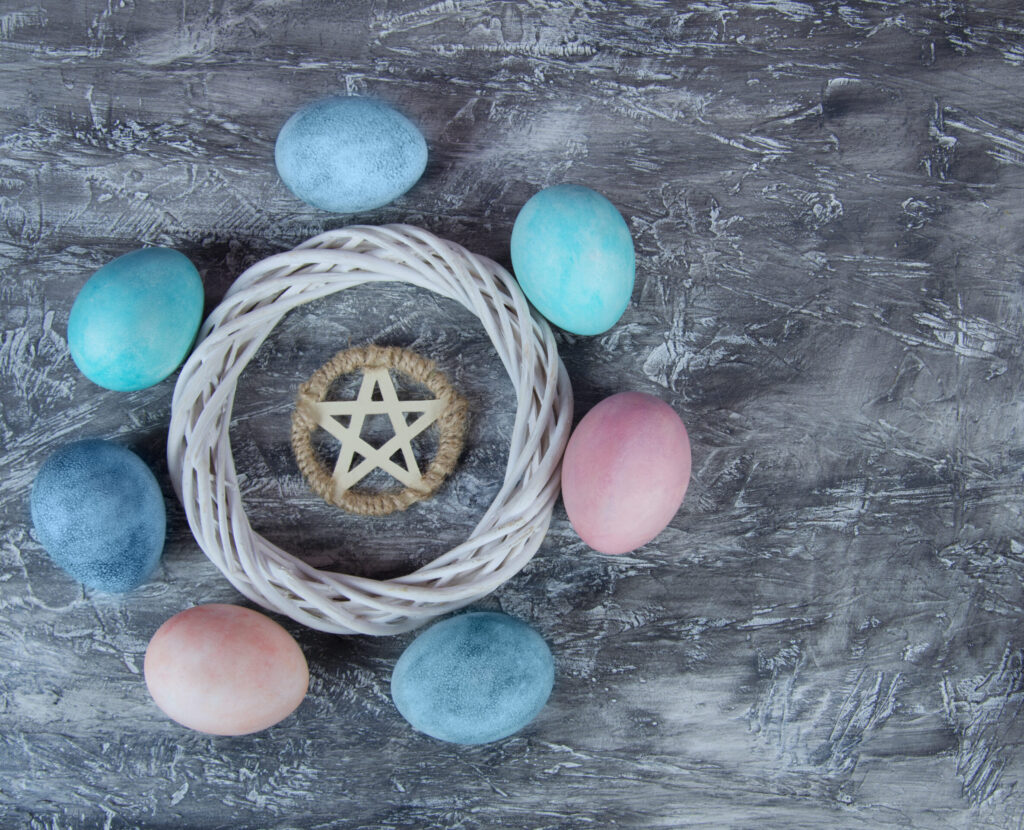 Ostara colored eggs circling a woven wreath and pentagram