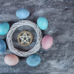 Ostara colored eggs circling a woven wreath and pentagram
