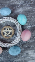 Ostara colored eggs circling a woven wreath and pentagram