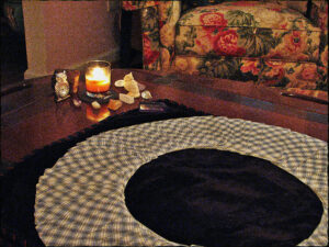 my reading room with circular tarot card layout on table with candle and magical items