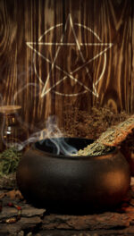 Samhain altar with pentagram sign, burning candles, dry herbs, iron cauldron, smoking mugwort, bunch of garlic