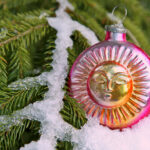 Solstice Sun vintage glass ornament with snow on Yule tree