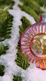 Solstice Sun vintage glass ornament with snow on Yule tree