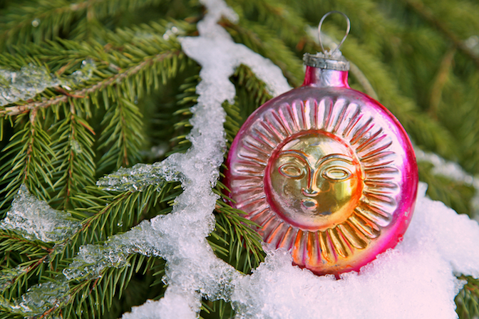 Solstice Sun vintage glass ornament with snow on Yule tree