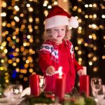 Child lighting a candle on advent wreath