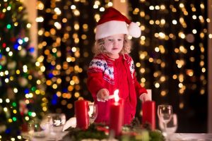 Child lighting a candle on advent wreath