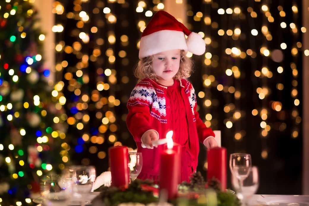 Child lighting a candle on advent wreath