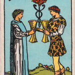 Waite-Smith Tarot two of cups young couple exchanging golden goblets and blessed by lion creature above
