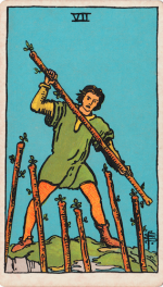 Waite-Smith Tarot Seven of Wands Young man in green tunic holding stave stands on edge of cliff prepared for battle